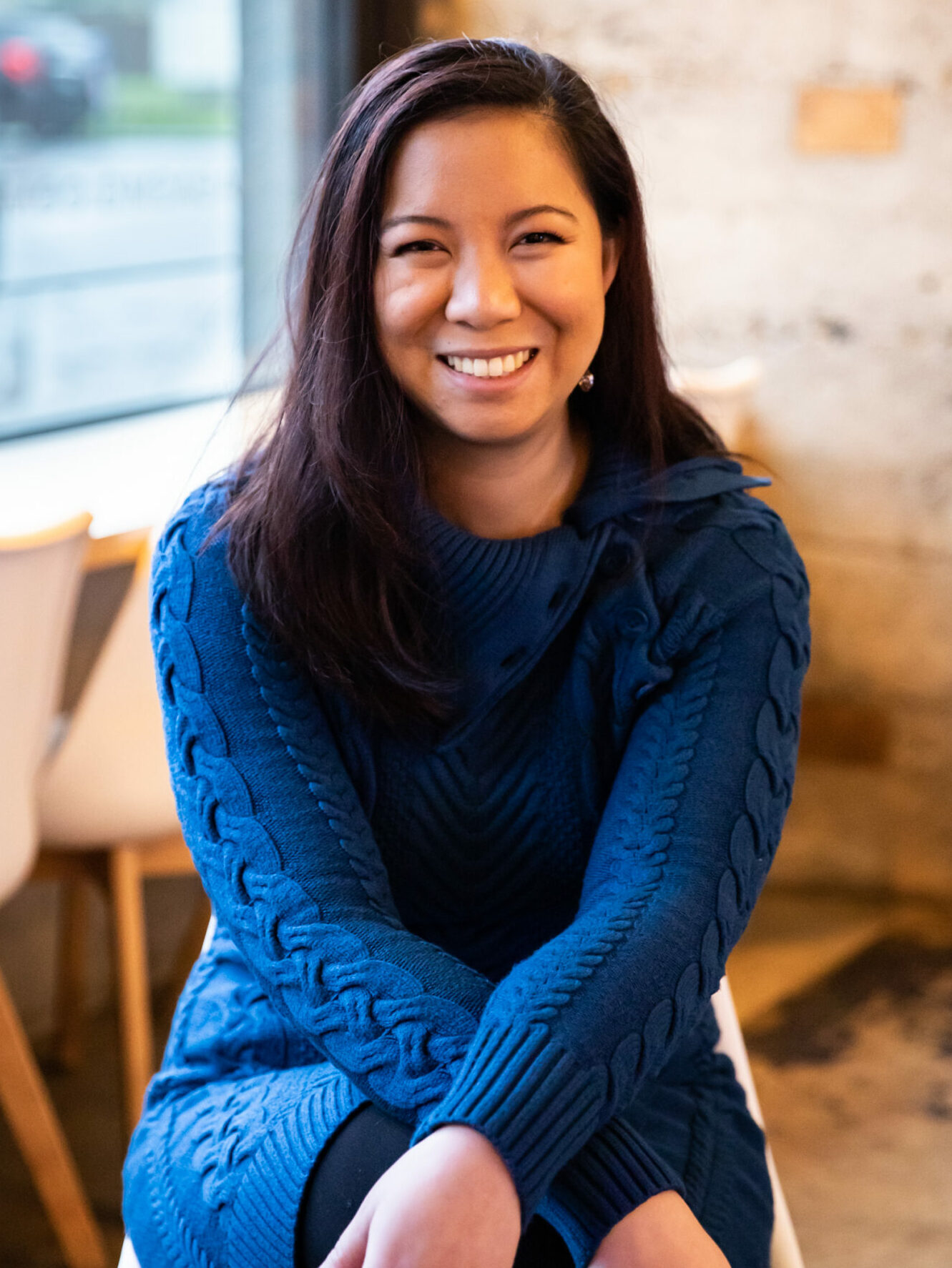Photo of Amy Homer-Brown seated in a blue turtleneck sweater.